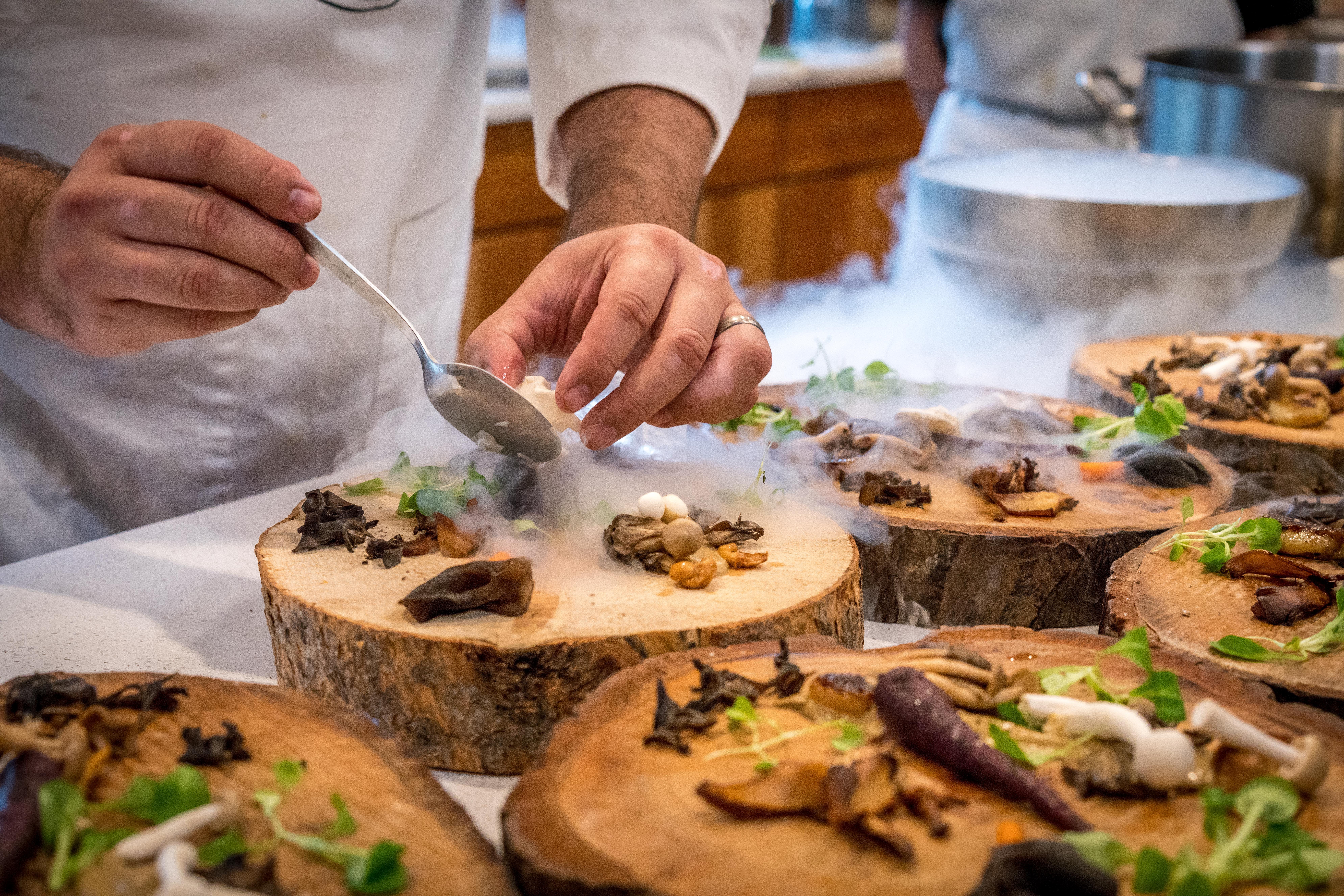 Chef preparing vegetable dish on tree slab